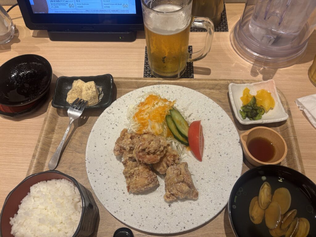 唐揚げ定食とビールが並ぶテーブル