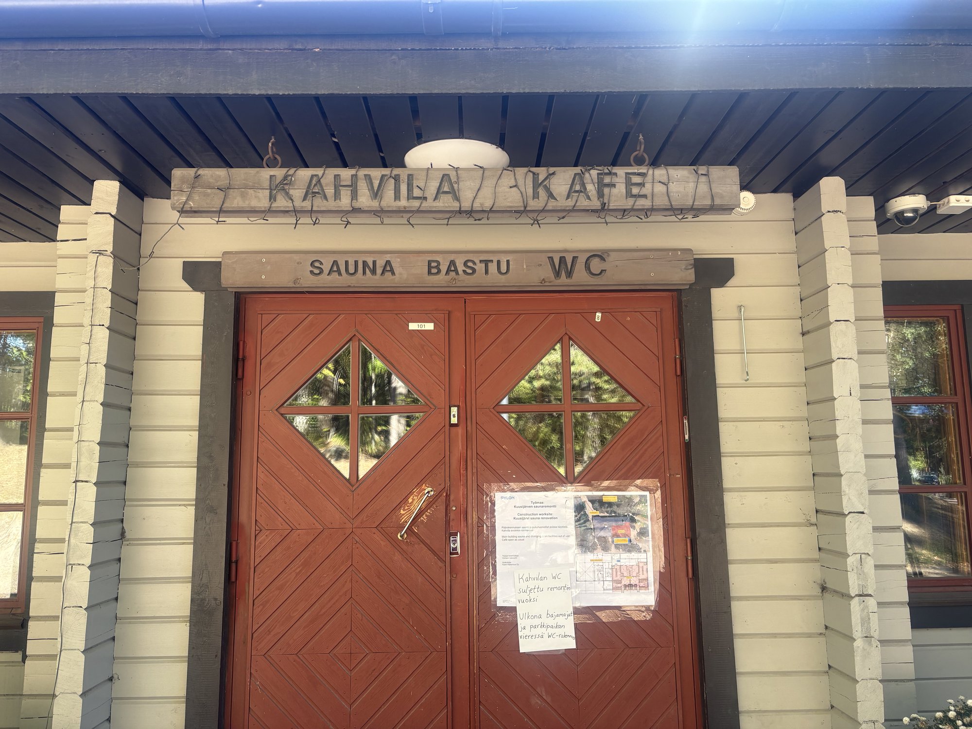 カフェ兼サウナ受付の入口、「KAHVILA / KAFE」「SAUNA BASTU WC」の看板
