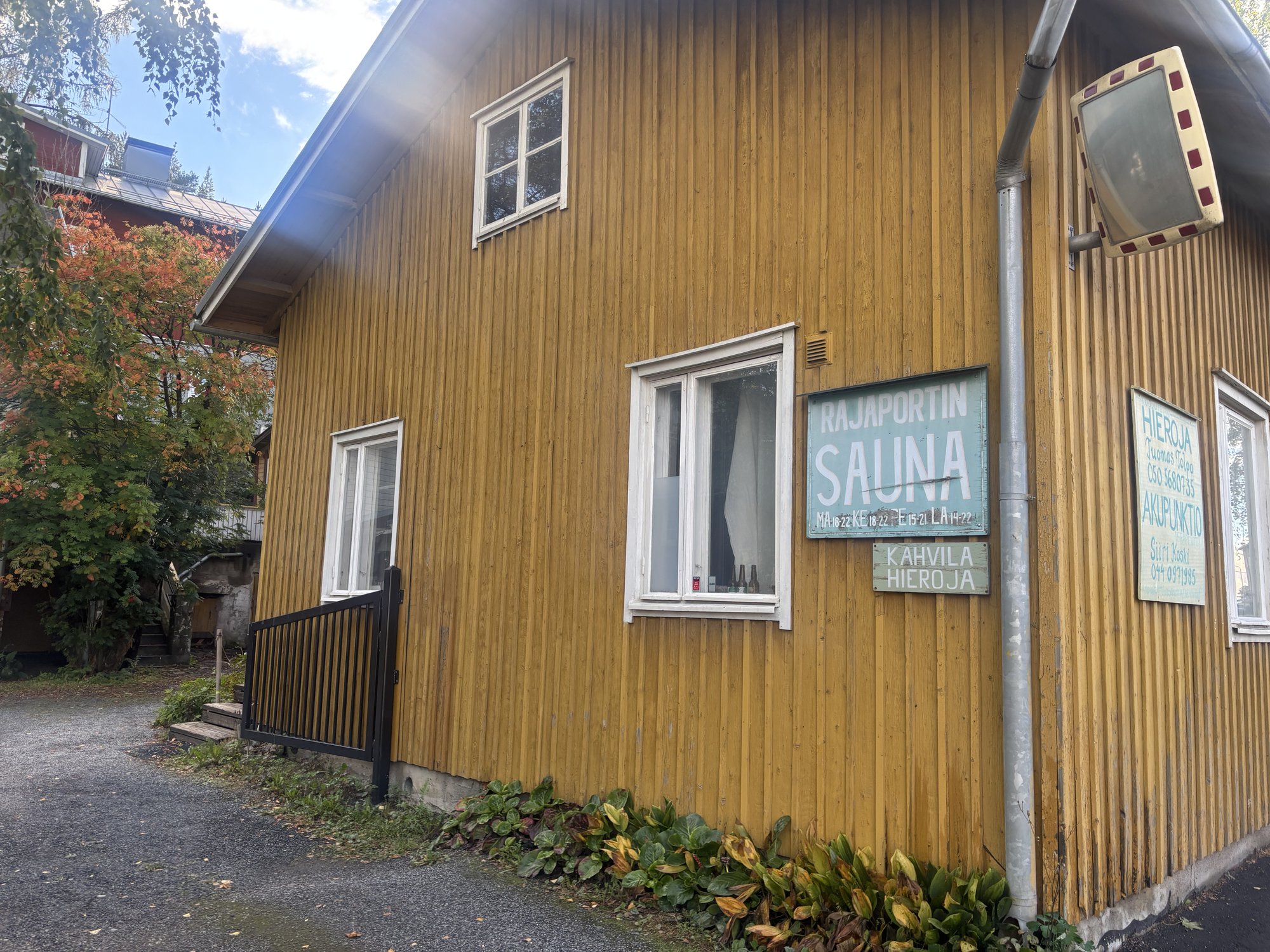 建物の外壁に並ぶ「RAJAPORTIN SAUNA」「KAHVILA」「HIEROJA / AKUPUNKTIO」の看板