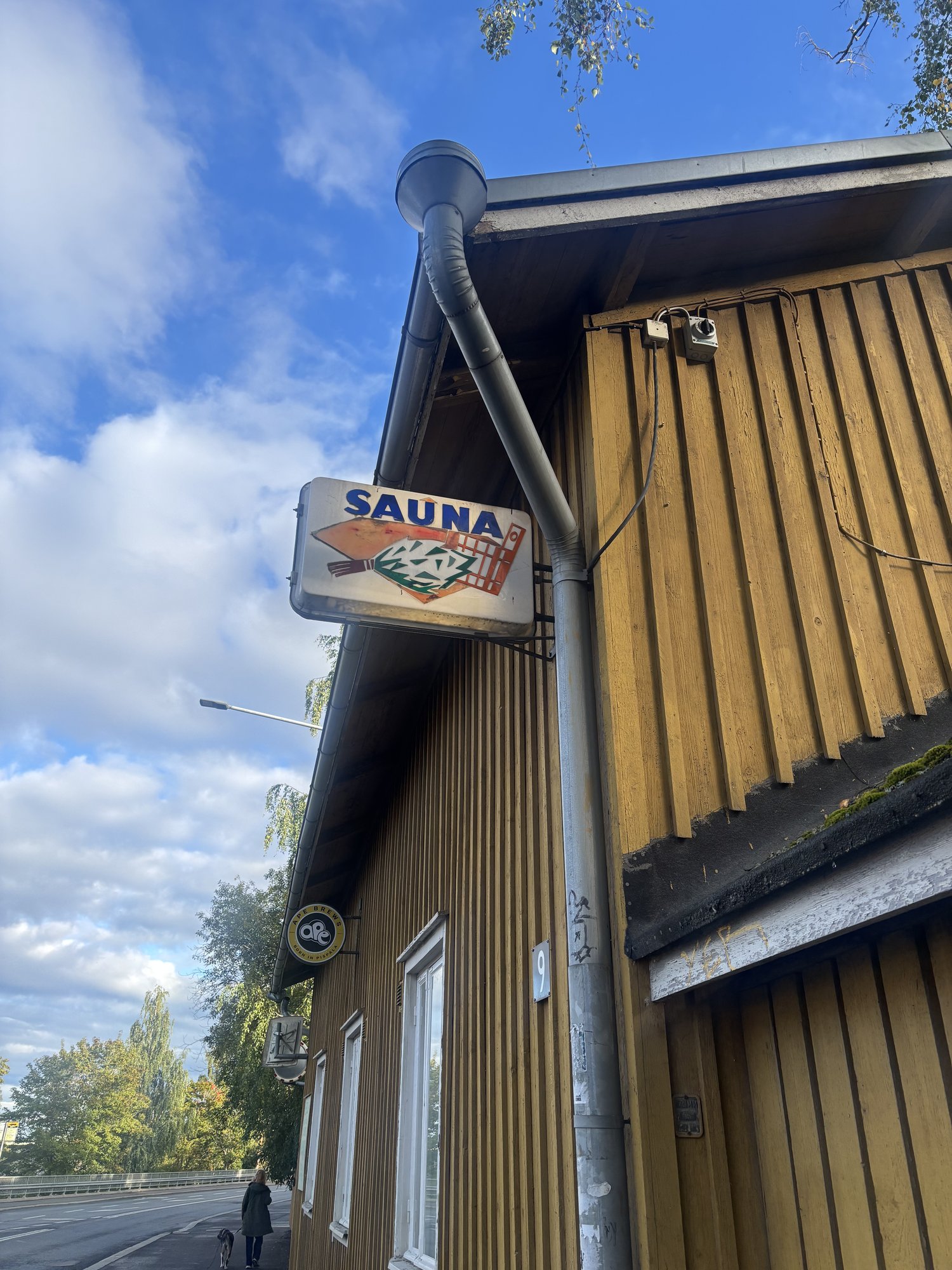 建物の角に掲げられた「SAUNA」の看板(サウナウィスクのイラスト付き)